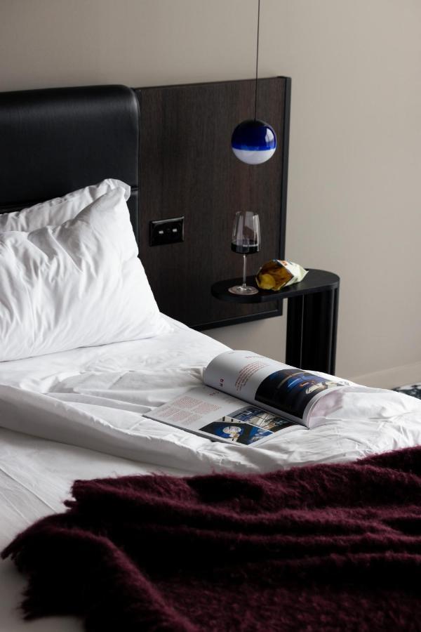 Ebb-Dunedin Dış mekan fotoğraf A bed with a magazine and a wine bottle